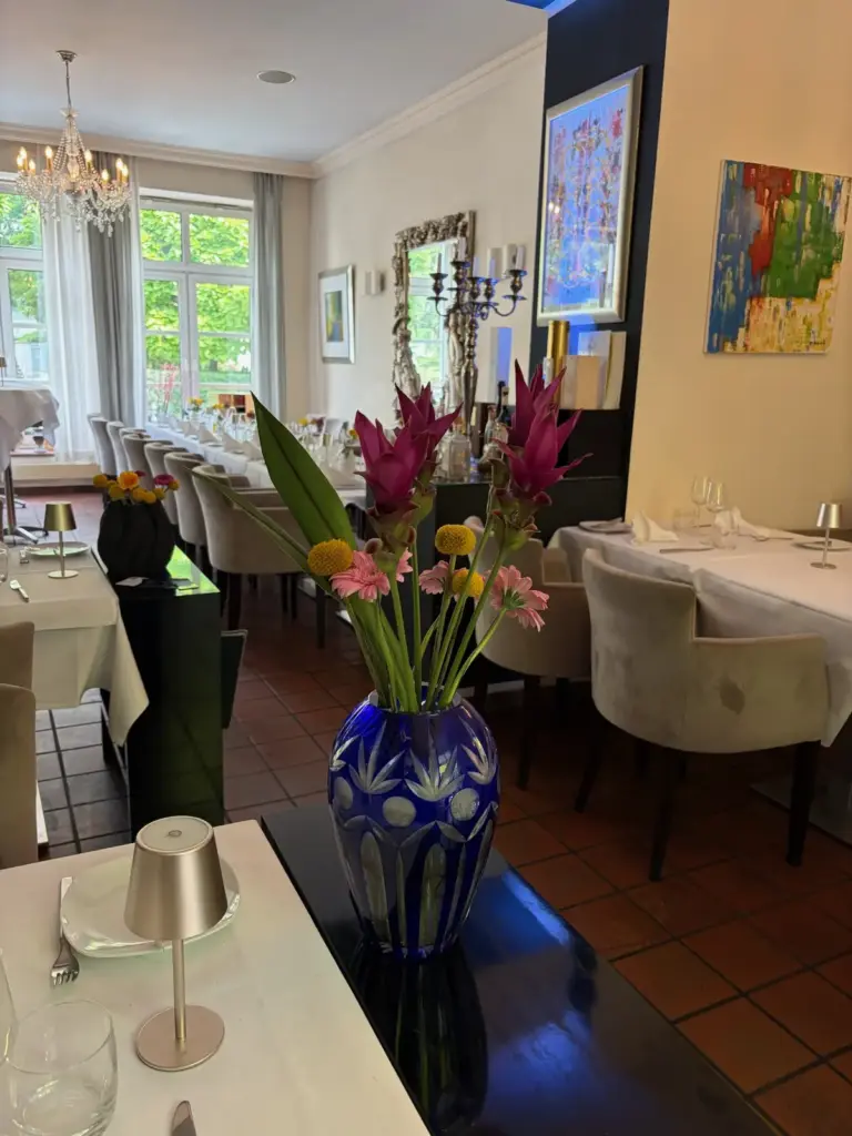Gastraum mit Blumenarrangement und gedeckten Tischen