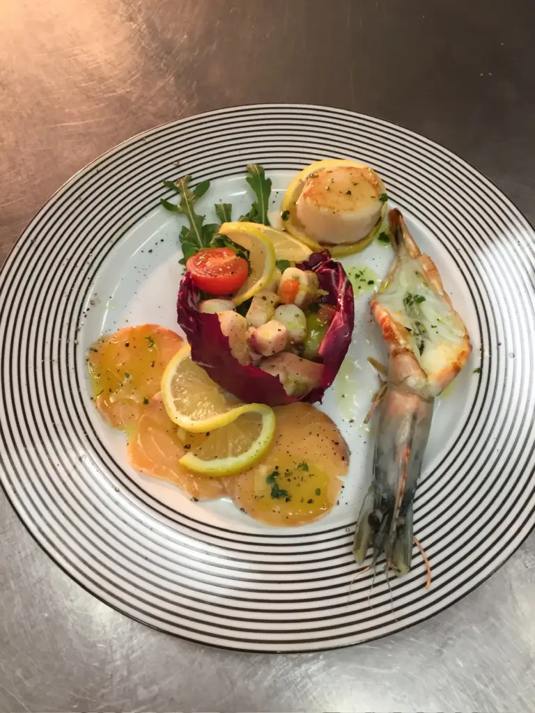 Fischgericht mit Gemüse und Orangenscheiben