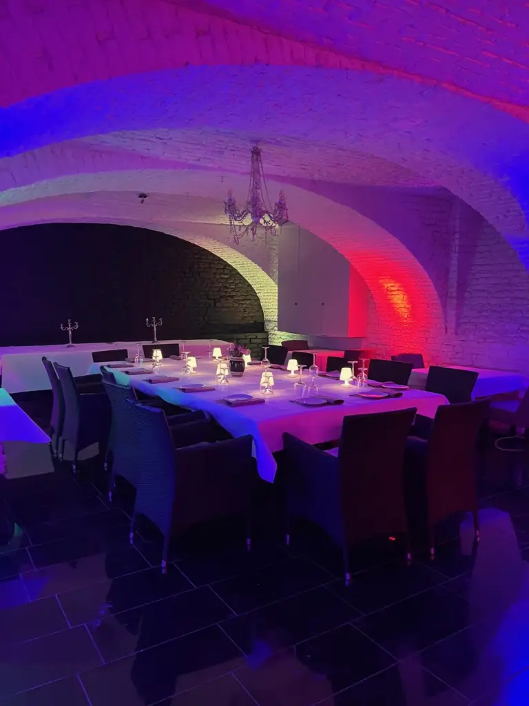 Gewölbekeller mit festlich gedeckter Tafel und farbigem Licht