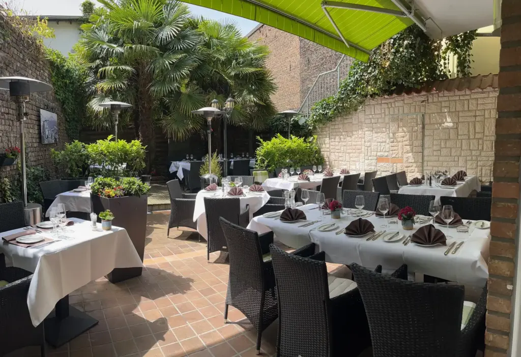 Festlich gedeckte Terrasse im begrünten Innenhof