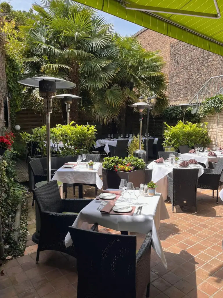 Blick über die Terrasse mit Heizstrahlern und Palmen
